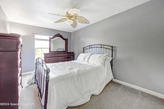 carpeted bedroom with ceiling fan and a textured ceiling