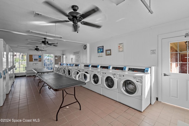 laundry area with ceiling fan, wood walls, washer and clothes dryer, light tile patterned flooring, and stacked washer and clothes dryer