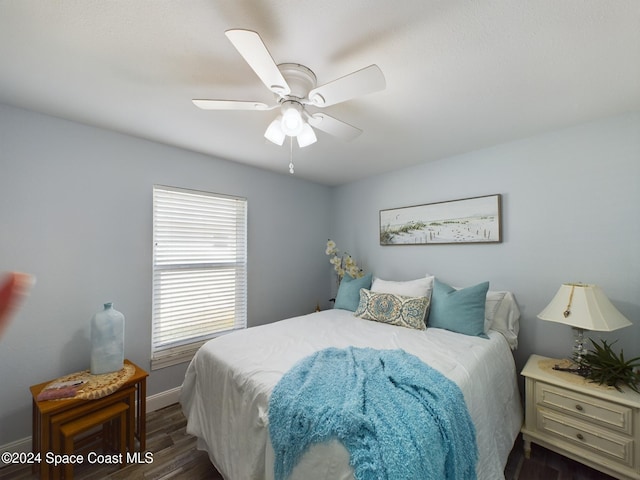 bedroom with dark hardwood / wood-style flooring and ceiling fan