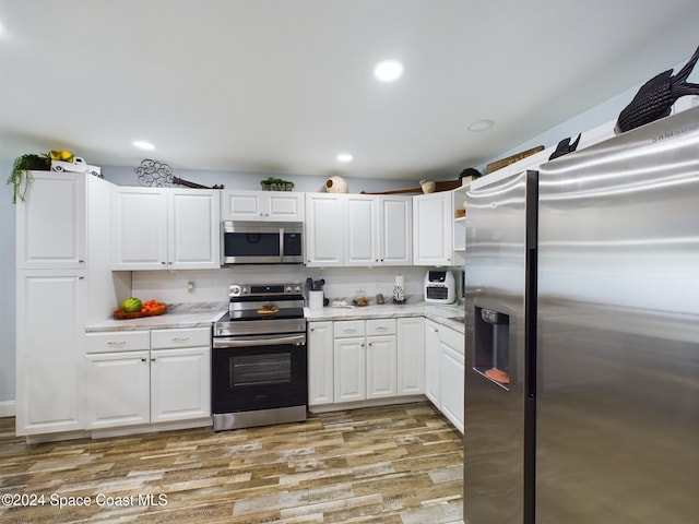 kitchen featuring light hardwood / wood-style flooring, white cabinets, and stainless steel appliances