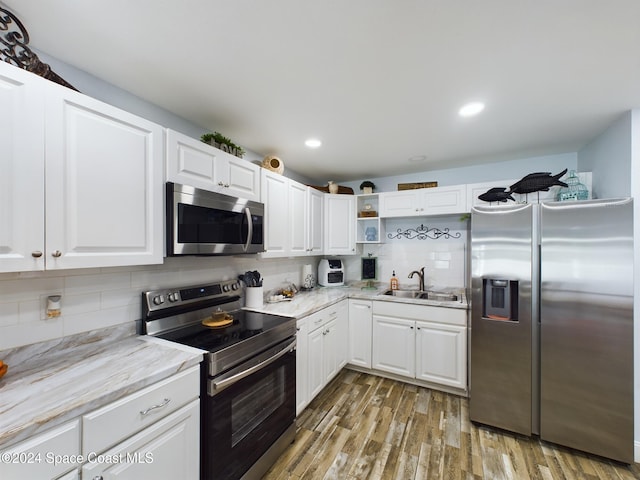 kitchen with hardwood / wood-style floors, white cabinetry, sink, and appliances with stainless steel finishes