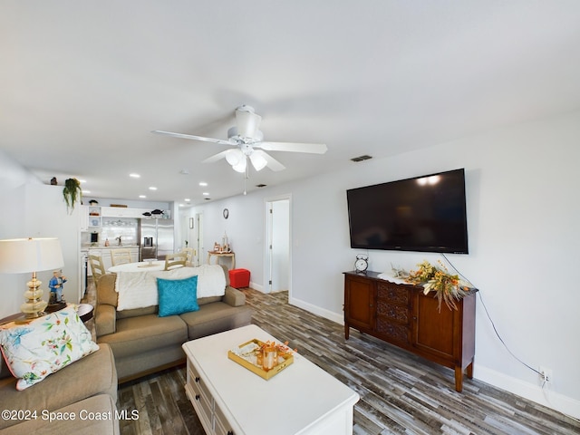 living room featuring ceiling fan and dark hardwood / wood-style flooring