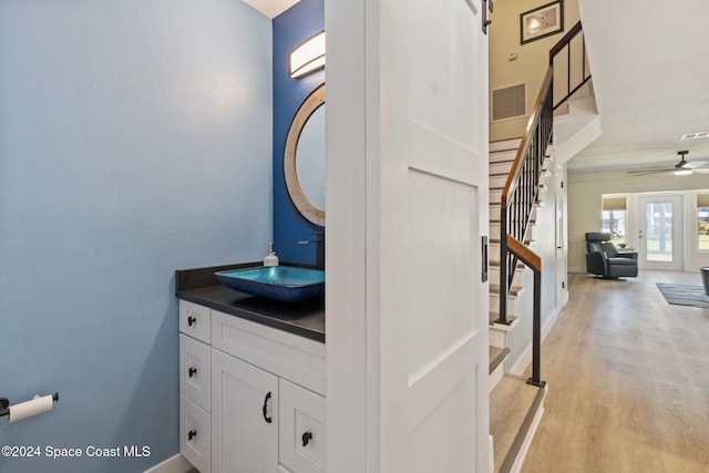 bathroom featuring ceiling fan, french doors, vanity, and wood-type flooring