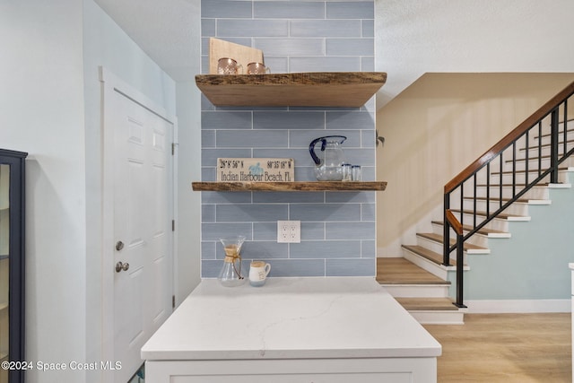 interior space featuring backsplash and light wood-type flooring