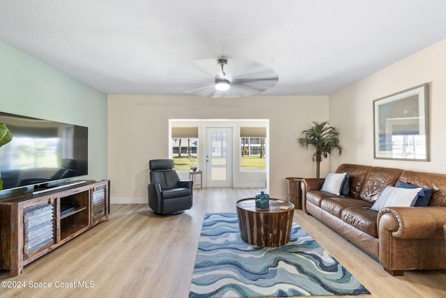 living room with ceiling fan and light hardwood / wood-style floors