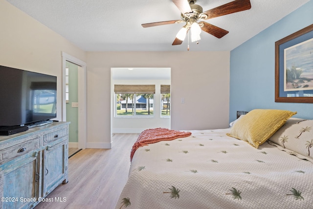 bedroom featuring ceiling fan, light hardwood / wood-style floors, a textured ceiling, and a closet