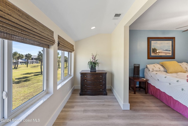 bedroom featuring light hardwood / wood-style flooring and lofted ceiling