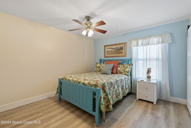 bedroom with light hardwood / wood-style floors and ceiling fan