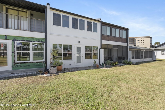 rear view of house featuring a lawn