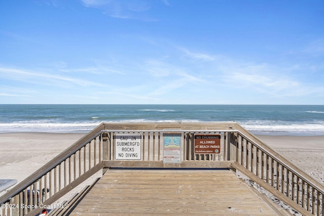 wooden terrace with a view of the beach and a water view