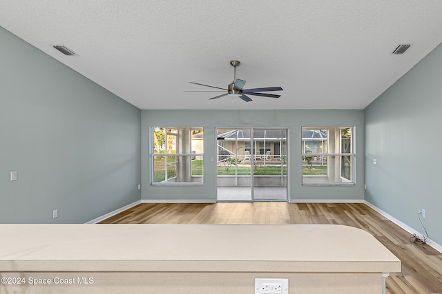 spare room featuring a textured ceiling, hardwood / wood-style flooring, and ceiling fan