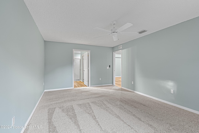 carpeted spare room featuring ceiling fan and a textured ceiling