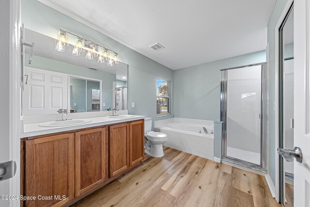 full bathroom featuring hardwood / wood-style floors, vanity, toilet, and plus walk in shower