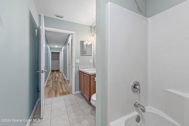 full bathroom featuring hardwood / wood-style floors, vanity, toilet, and shower / tub combination