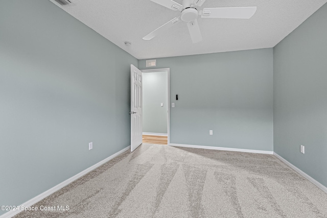 empty room featuring carpet, a textured ceiling, and ceiling fan