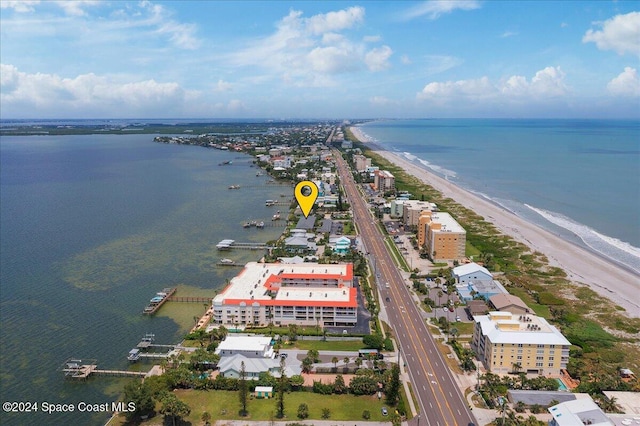 birds eye view of property featuring a water view and a beach view