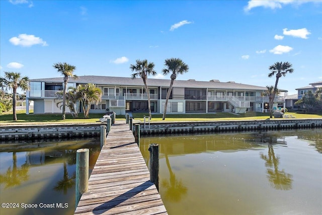 dock area with a water view and a yard