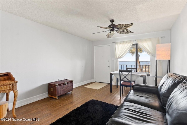 living room with wood-type flooring, a textured ceiling, and ceiling fan