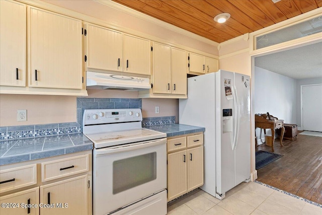 kitchen featuring crown molding, light tile patterned floors, wooden ceiling, and white appliances