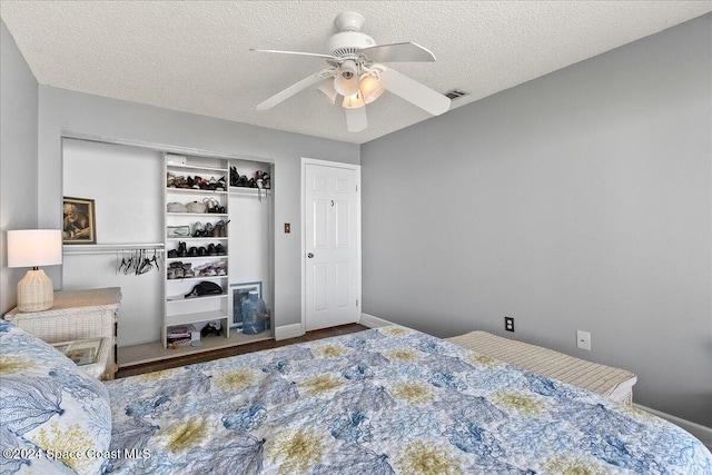 bedroom featuring ceiling fan, a closet, and a textured ceiling