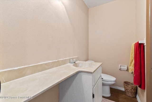 bathroom featuring vanity, wood-type flooring, and toilet