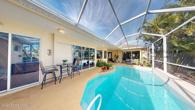 view of swimming pool with glass enclosure and a patio area