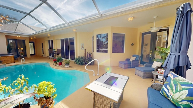 view of pool featuring glass enclosure, ceiling fan, and a patio