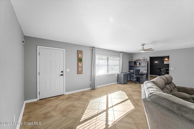 living room featuring ceiling fan and a textured ceiling