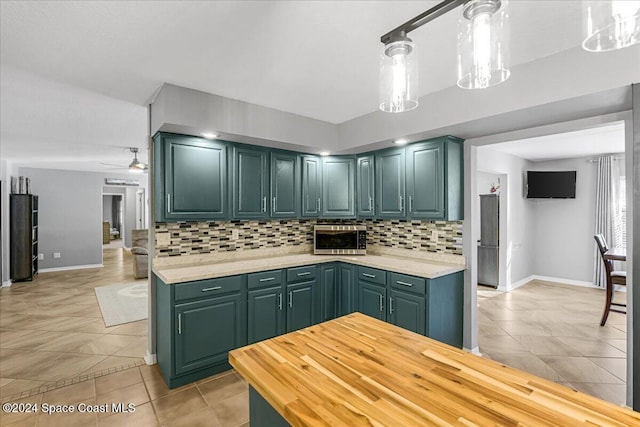 kitchen featuring decorative backsplash, pendant lighting, and green cabinetry