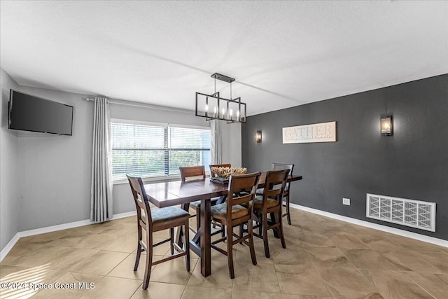 tiled dining space featuring a chandelier