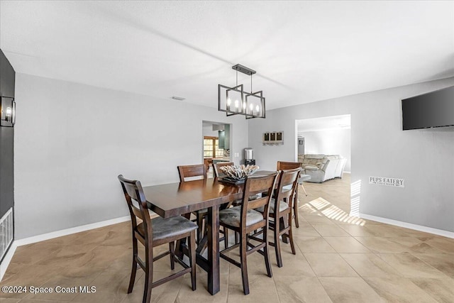 dining space featuring light tile patterned floors and a chandelier