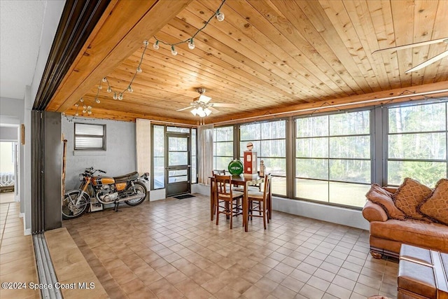 sunroom / solarium with ceiling fan, plenty of natural light, and wood ceiling