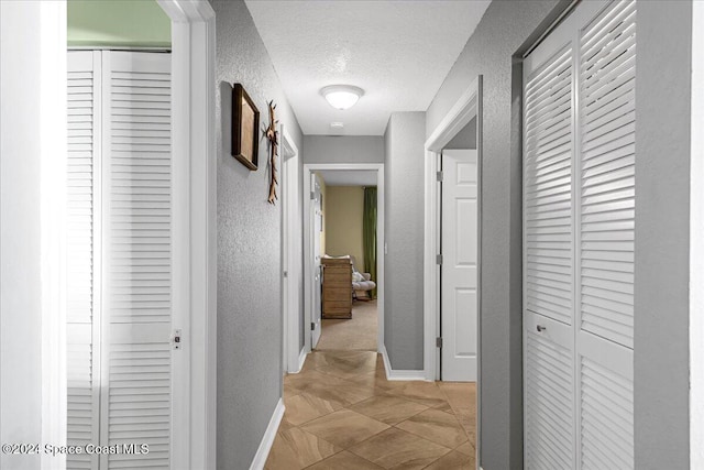 corridor featuring a textured ceiling