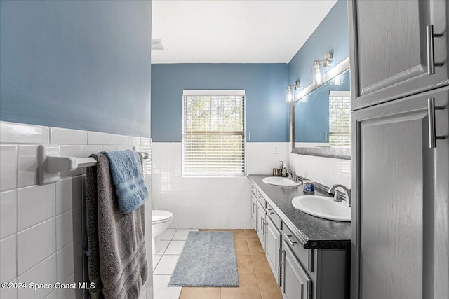 bathroom with tile patterned floors, vanity, toilet, and tile walls