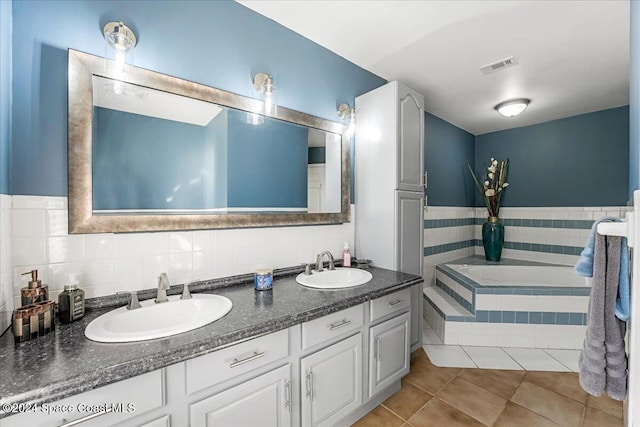 bathroom with vanity, tile patterned floors, tile walls, and a tub