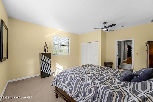 carpeted bedroom with a closet and ceiling fan