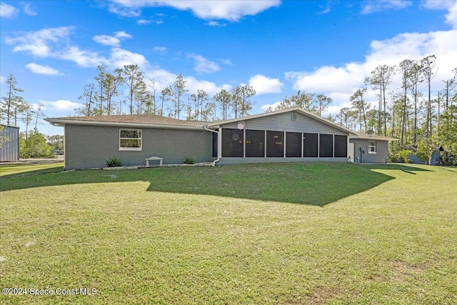 back of property with a lawn and a sunroom