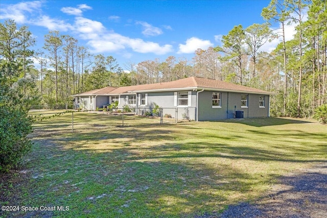 back of property with a lawn and central AC unit