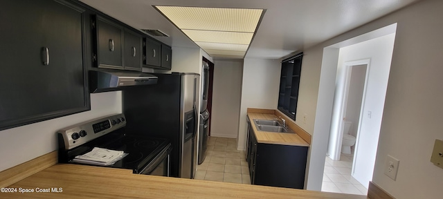 kitchen featuring ventilation hood, electric stove, sink, light tile patterned floors, and butcher block countertops