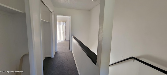 hallway featuring carpet and a textured ceiling