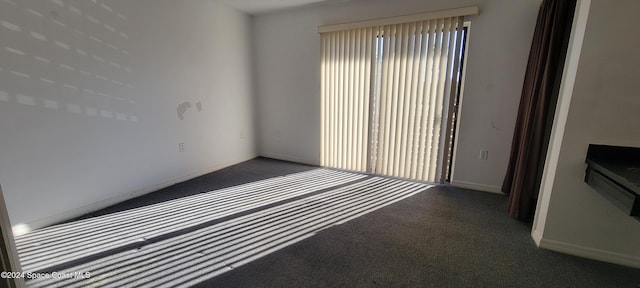 unfurnished room with dark colored carpet