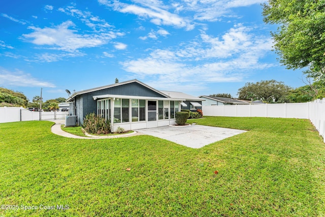 rear view of property featuring a sunroom, a yard, cooling unit, and a patio