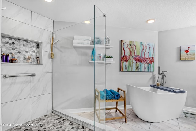 bathroom featuring separate shower and tub and a textured ceiling