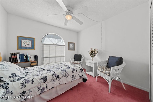 carpeted bedroom with ceiling fan and a textured ceiling