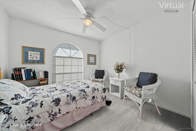 bedroom with ceiling fan, light wood-type flooring, and a textured ceiling