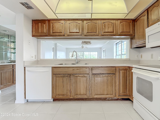 kitchen featuring white appliances, sink, and light tile patterned floors