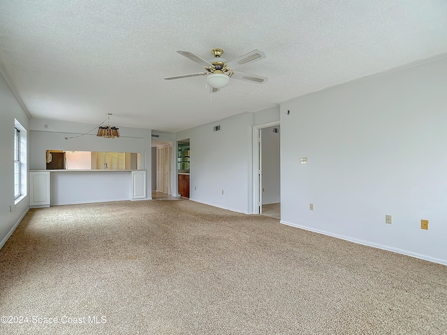 unfurnished living room with carpet flooring, a textured ceiling, and ceiling fan with notable chandelier