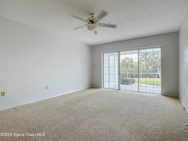 carpeted spare room featuring ceiling fan and a textured ceiling