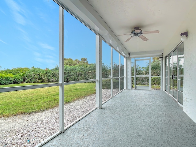 unfurnished sunroom with ceiling fan