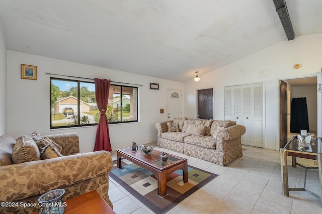 living room featuring vaulted ceiling with beams, light tile patterned floors, and a textured ceiling